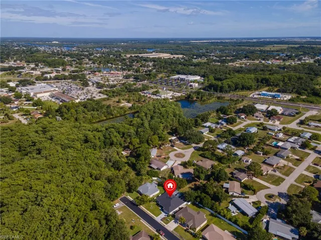 Aerial perspective showcasing a residential neighborhood with ample green space and a body of water