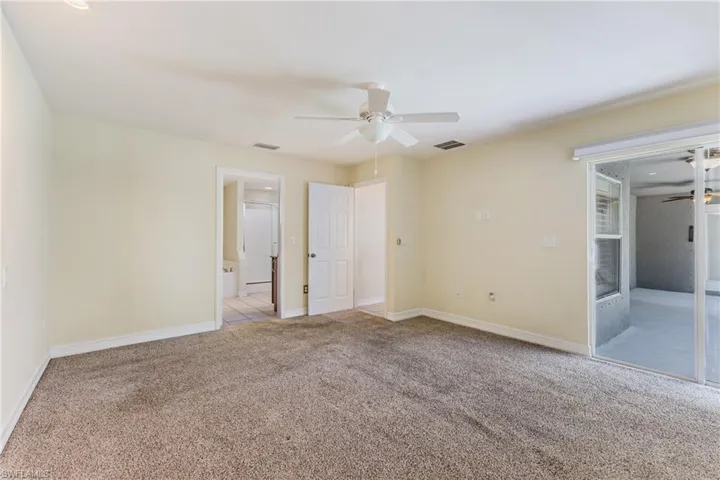 Spacious room with plush carpet flooring and light-toned walls