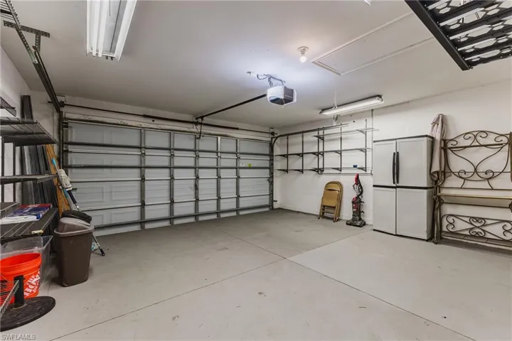 Spacious garage with light grey concrete flooring and a white sectional garage door