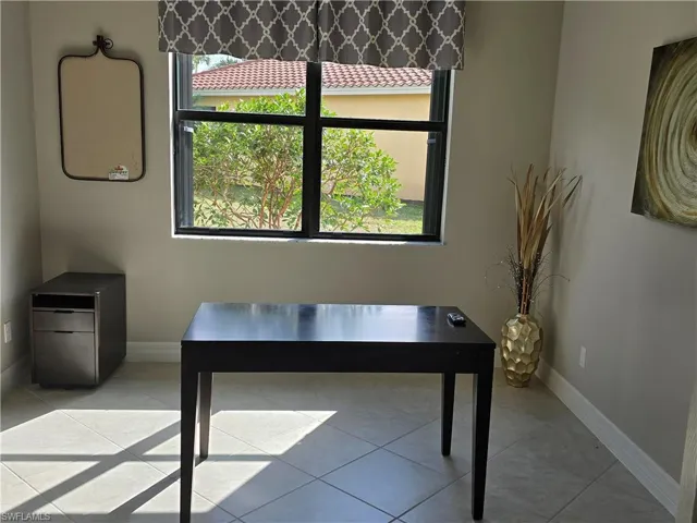 Office featuring light tile patterned flooring and a healthy amount of sunlight
