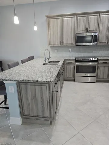 Kitchen featuring stove, a breakfast bar, sink, and kitchen peninsula