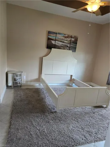 Unfurnished bedroom featuring ceiling fan and tile patterned floors