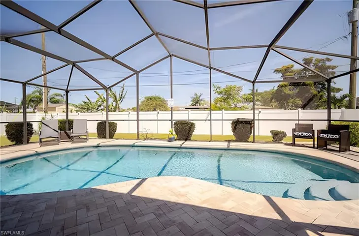 View of pool featuring glass enclosure, a sunroom, and a patio