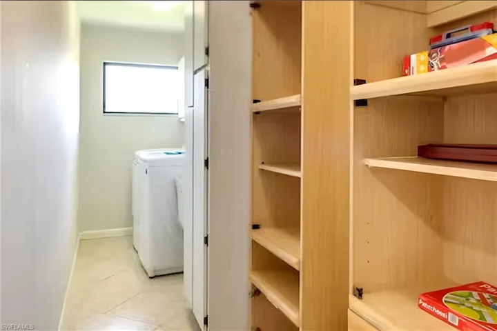Washroom featuring light tile patterned floors and washing machine and dryer