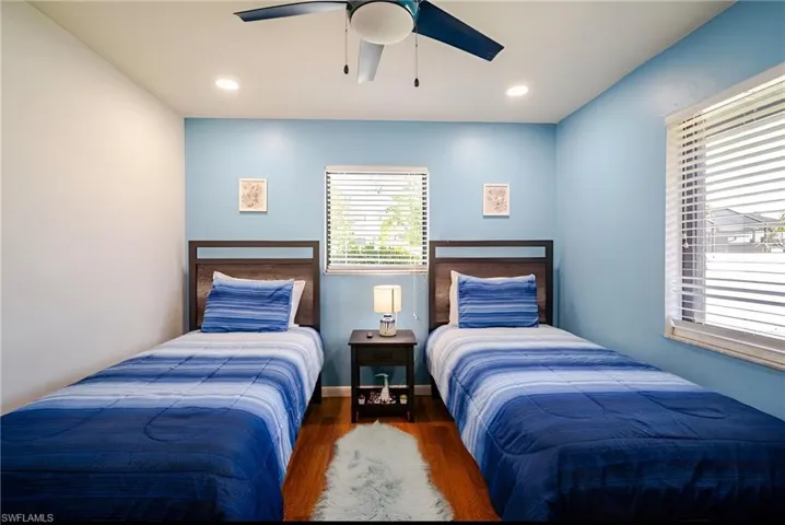 Bedroom with wood finished floors, a ceiling fan, and recessed lighting