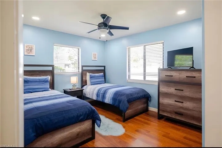 Bedroom with wood finished floors, multiple windows, recessed lighting, and ceiling fan