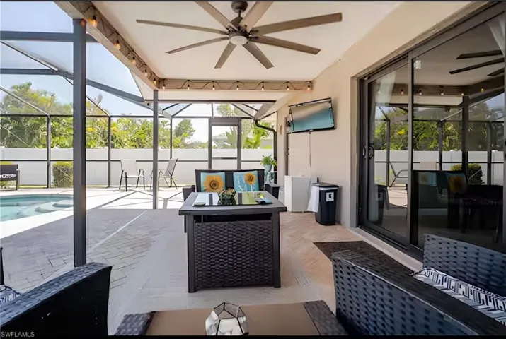 Sunroom / solarium featuring a ceiling fan, a patio area, outdoor lounge area, and a swimming pool