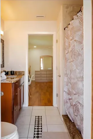 Full bathroom with vanity, light tile patterned floors, and a shower with shower curtain