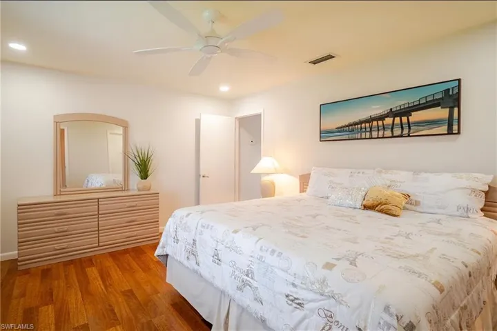 Bedroom with light wood-style floors, ceiling fan, and recessed lighting