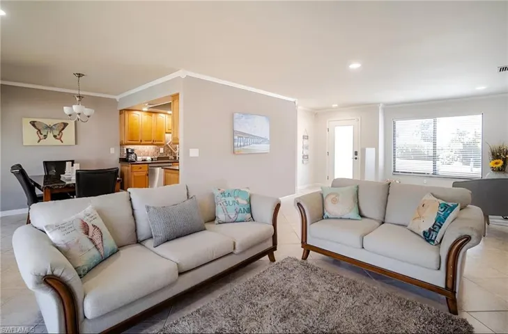 Living area featuring ornamental molding, light tile patterned floors, recessed lighting, and a chandelier
