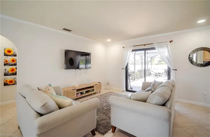 Living room featuring light tile patterned floors, ornamental molding, and recessed lighting