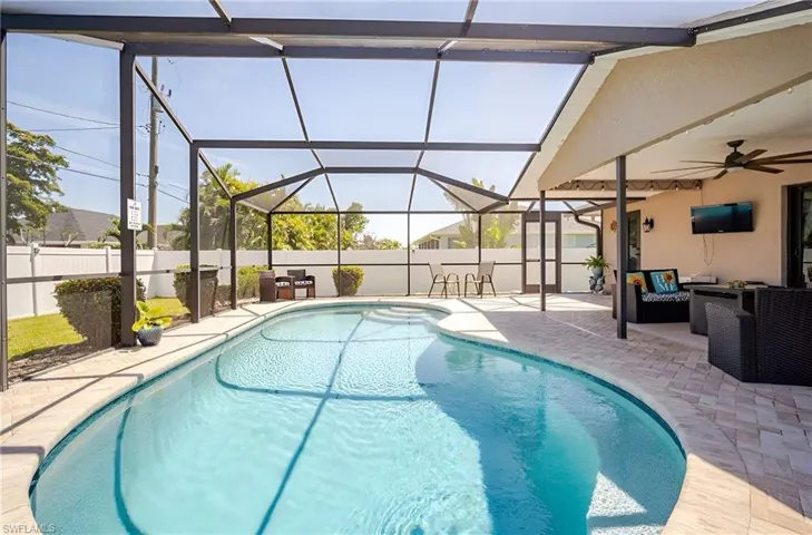 View of swimming pool featuring outdoor lounge area, a sunroom, ceiling fan, and glass enclosure