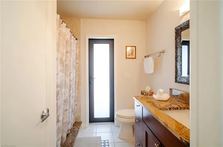Full bath featuring vanity, light tile patterned flooring, and a shower with curtain