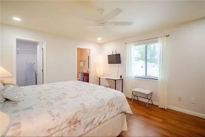 Bedroom featuring wood finished floors, ceiling fan, connected bathroom, and recessed lighting