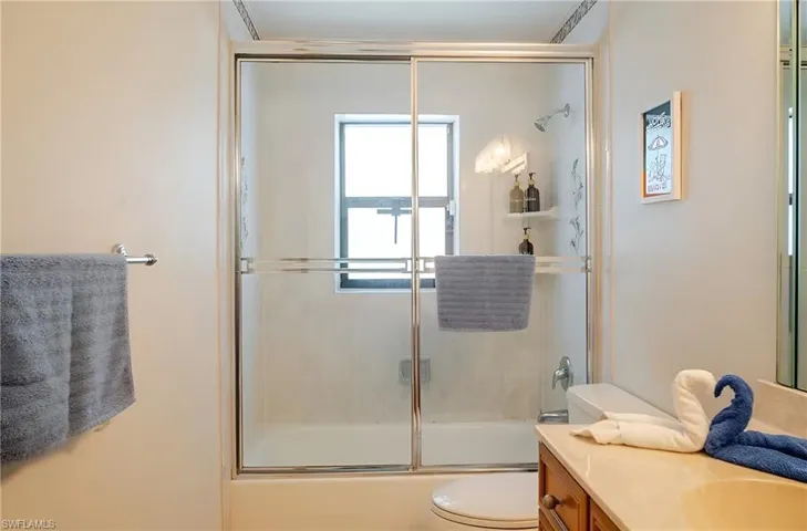 Full bath featuring enclosed tub / shower combo and vanity