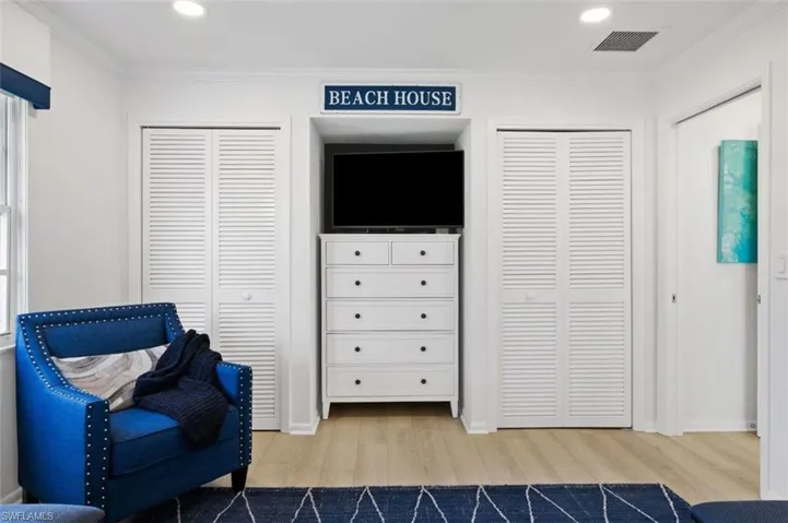 Sitting room featuring light wood-type flooring, crown molding, and recessed lighting