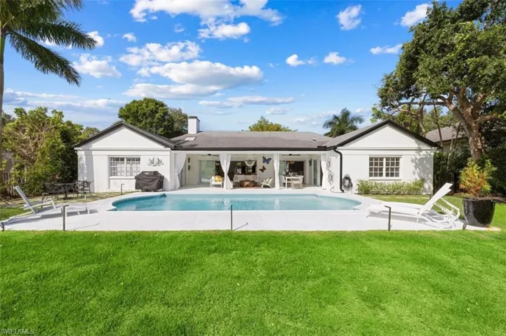 Back of property featuring a patio, an outdoor pool, a yard, and a chimney