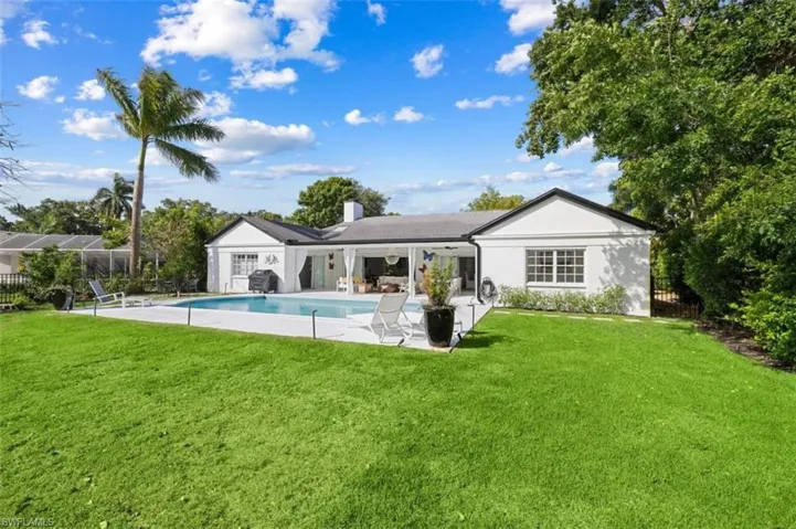 Back of property featuring a patio area, an outdoor pool, and a chimney