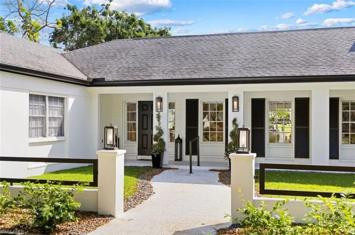 Doorway to property featuring roof with shingles, a porch, and stucco siding