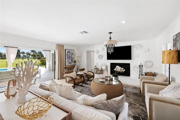 Living area featuring a fireplace, healthy amount of natural light, crown molding, and recessed lighting