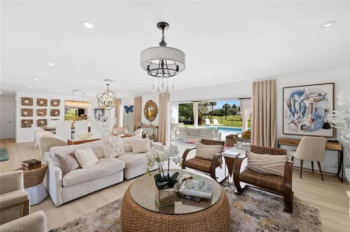 Living area with light wood-style flooring, a chandelier, and recessed lighting