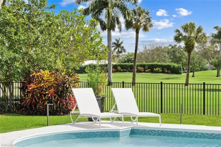 View of swimming pool with a fenced backyard, a patio, view of wooded area, and view of golf course