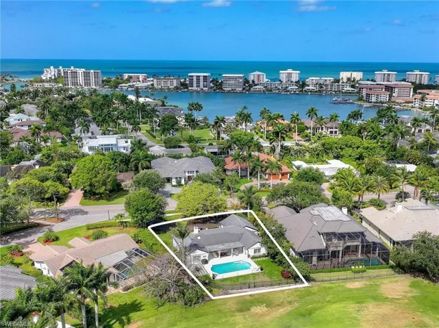 Aerial perspective of suburban area featuring property parcel outlined and a large body of water