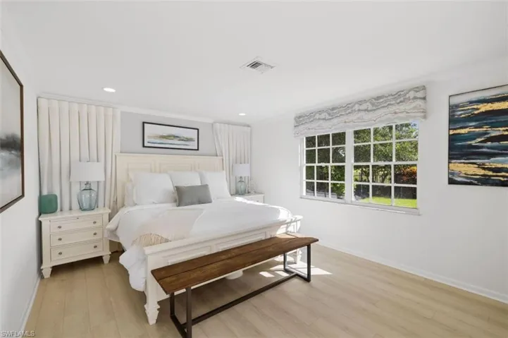 Bedroom with light wood-style floors, recessed lighting, and ornamental molding
