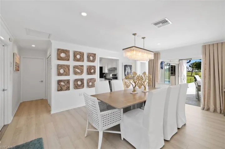Dining area featuring light wood-style floors, attic access, ornamental molding, and recessed lighting