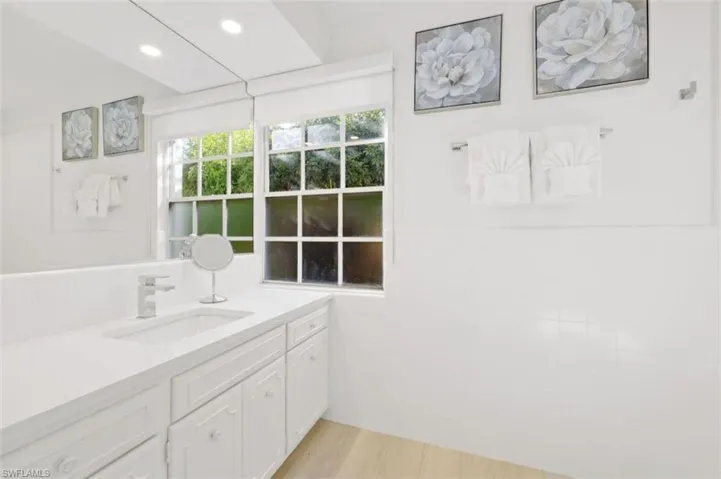 Bathroom featuring vanity, tile walls, and light wood-style floors
