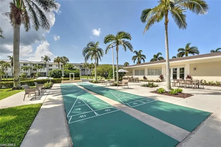 View of property's community with shuffleboard and a patio area
