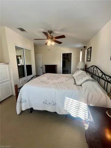 Bedroom with carpet floors, a ceiling fan, and a spacious closet