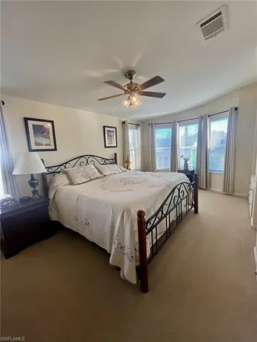 Bedroom with multiple windows, carpet, and a ceiling fan