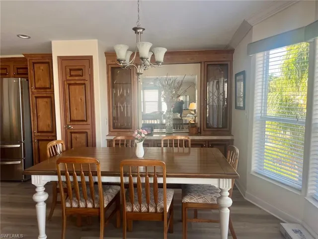 Dining area with dark wood-type flooring and a chandelier