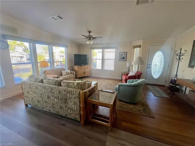 Living room featuring crown molding, ceiling fan, and wood finished floors