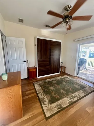 Bedroom featuring wood finished floors, ceiling fan, and access to outside