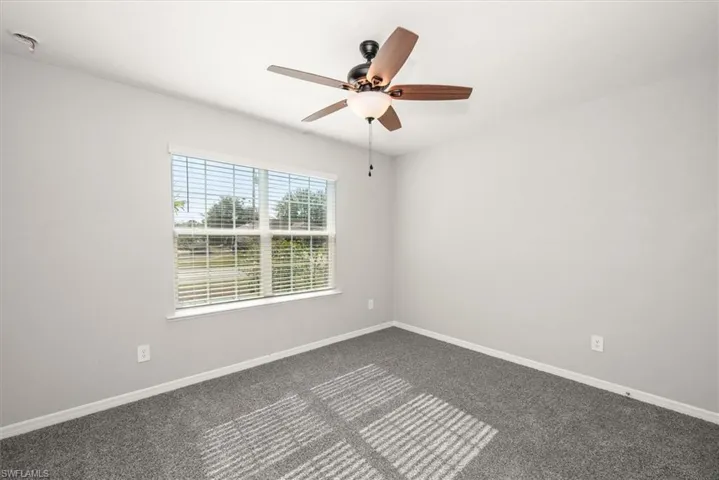 Spare room with carpet flooring and ceiling fan