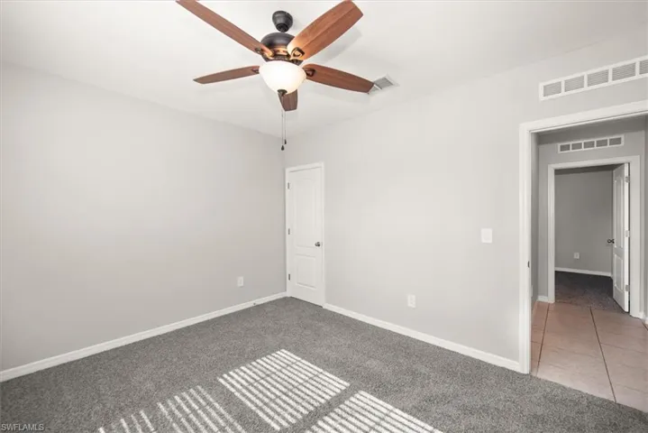 Spare room with light colored carpet and a ceiling fan