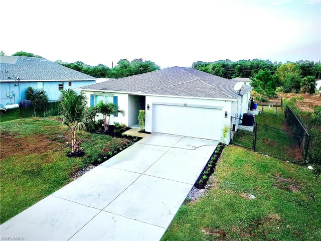 Ranch-style home with stucco siding, concrete driveway, a garage, a gate, and a shingled roof