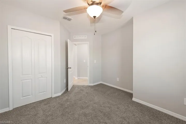Unfurnished bedroom featuring ceiling fan, carpet floors, and a closet