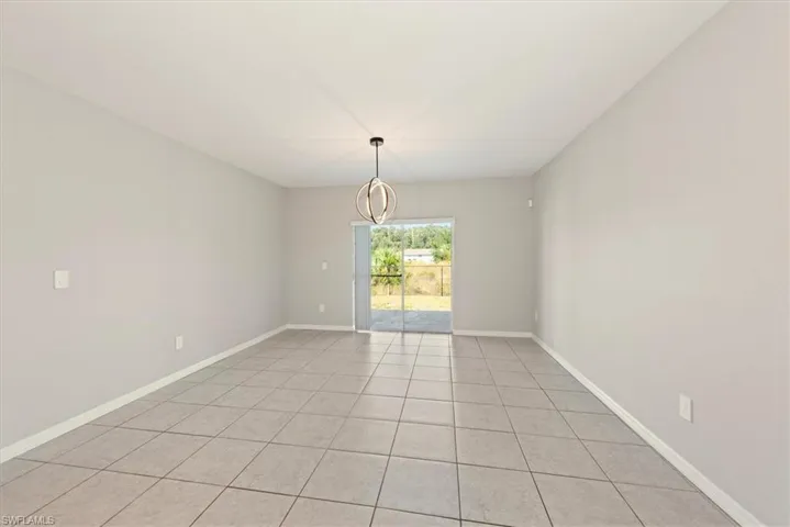 Spare room with light tile patterned floors and a chandelier