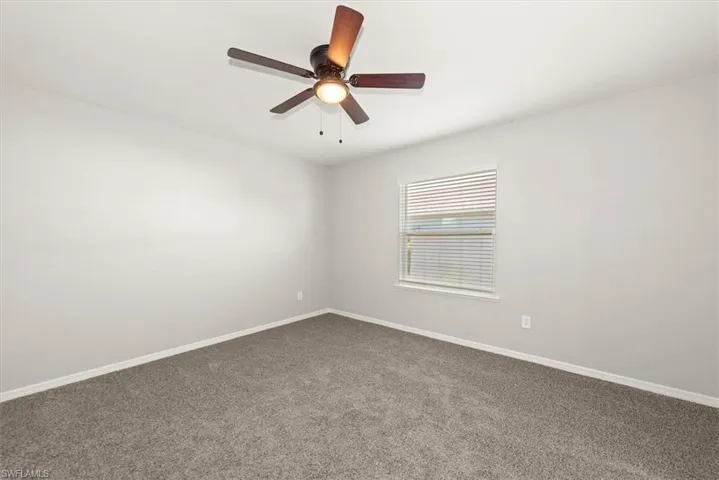 Spare room featuring carpet flooring and ceiling fan