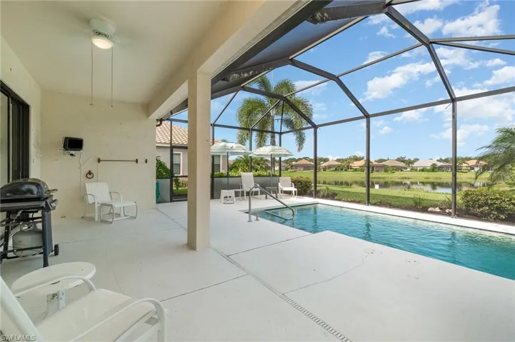 View of swimming pool featuring glass enclosure and a patio area