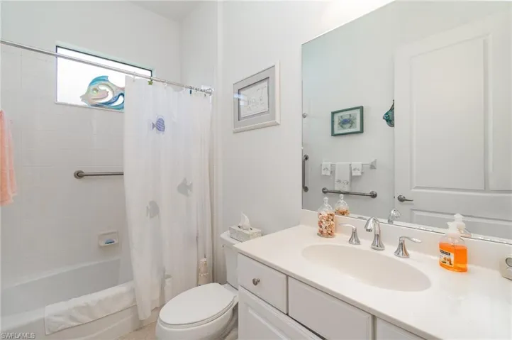 Full bathroom with shower / bath combination with curtain, vanity, and toilet