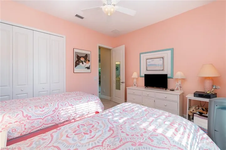 Bedroom featuring ceiling fan, a closet, and light colored carpet