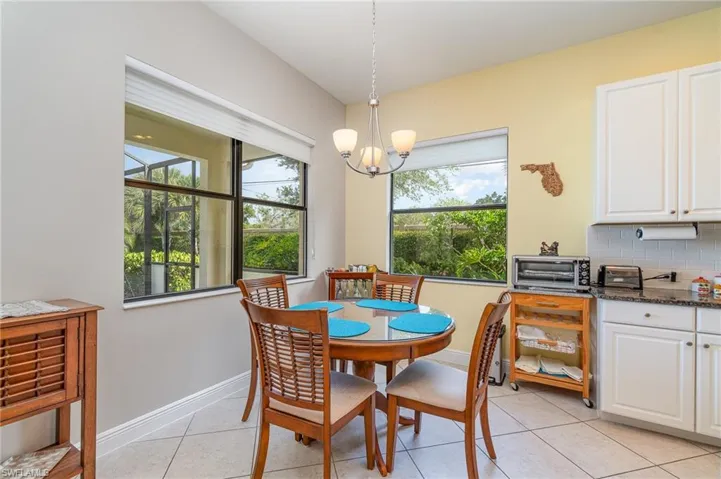 Tiled dining room with a notable chandelier and plenty of natural light
