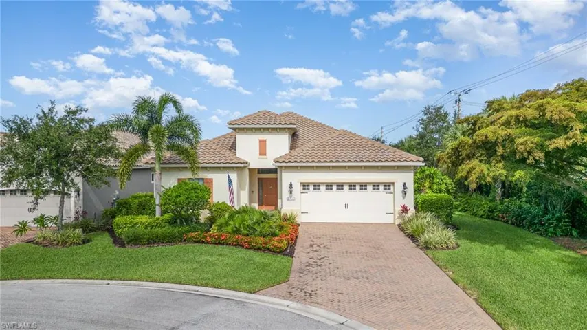 Mediterranean style house featuring a garage and a front lawn