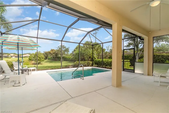 View of swimming pool featuring a patio area, a lanai, and ceiling fan
