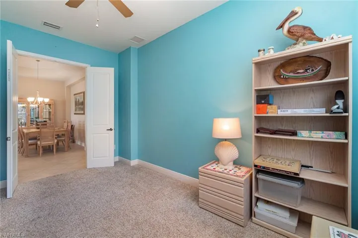 Living area featuring tile floors and ceiling fan with notable chandelier