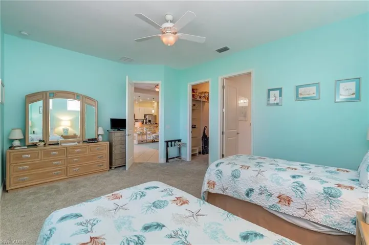 Bedroom with a walk in closet, carpet flooring, a closet, and ceiling fan